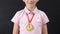 Smiling schoolboy with first place medal looking at camera, diligent student