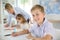 Smiling schoolboy writing in class