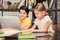 Smiling schoolchildren studying together and using laptop