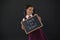 Smiling schoolgirl holding slate with text against blackboard