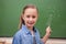 Smiling schoolgirl pointing at a bulb