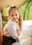 Smiling schoolgirl sitting at desk in bedroom