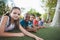 Smiling schoolkids lying on grass in campus