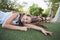 Smiling schoolkids lying on grass in campus