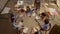 smiling schoolteacher helping students. School kids sitting at round desk