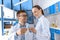 Smiling scientists in uniforms holding laboratory tubes