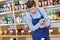 Smiling seller man wearing apron in wine store