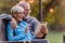 Smiling senior active couple sitting on the bench looking at tablet computer