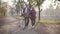 Smiling senior Caucasian couple walking with bicycle along the alley in the foggy park. Happy retired mature family