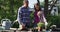 Smiling senior caucasian father and teenage daughter working in garden and inspecting plants