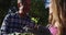 Smiling senior caucasian father and teenage daughter working in garden and inspecting plants