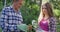 Smiling senior caucasian father and teenage daughter working in garden and watering plants