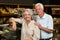 Smiling senior couple at the bakery store