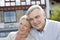 Smiling senior couple in front of home