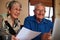 Smiling Senior Couple At Home Checking Personal Finances On Laptop
