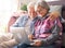 Smiling senior couple at home using together a laptop computer. Two elderly retirees enjoying free time and technological devices