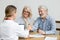 Smiling senior couple and realtor handshaking making real estate