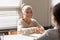 Smiling senior female patient handshake doctor at meeting