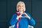 Smiling senior lady heart sign care harmony