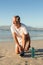 Smiling senior man tying shoelace at beach