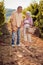 Smiling senior man and woman gather harvest grapes