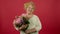 Smiling senior overweight woman sniffing flower bouquet