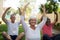 Smiling senior people exercising with arms raised