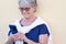 Smiling senior white haired woman using mobile phone in video call. Attractive retired people outdoor enjoying tech and social