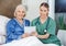 Smiling Senior Woman And Caretaker Holding Tablet