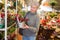 Smiling senior woman choosing christmas decorations in shop