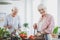 Smiling senior woman cutting tomatoes