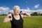 Smiling senior woman exercising with dumbells in park