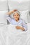 smiling senior woman lying in bed at home bedroom