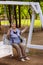 Smiling senior woman sitting on swing, having fun and enjoying retirement. joyful active retirement
