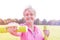 Smiling senior woman with sort hair exercising with weights in park