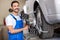 Smiling serviceman checking wheel