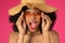 Smiling shocked cute young african american curly woman in sunglasses and hat with open mouth