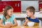 Smiling sibling having breakfast cereal in kitchen