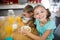 Smiling sibling having breakfast cereal in kitchen