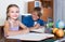 Smiling siblings doing homework with books