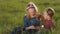 Smiling siblings relaxing on green grass in spring