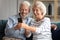 Smiling sincere mature older married family couple using smartphone.