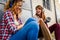 Smiling skateboarding girls sitting in the street hanging out