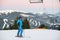 Smiling skiing woman standing in snow mountain under ski-lift