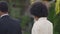 Smiling slim beautiful African American bride admiring groom and walking with partner to altar in slow motion in