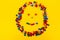 Smiling smiley from multi-colored round toys on a yellow background