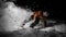 Smiling snowboarder in orange jacket riding on a snowy hill at n