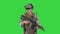 Smiling soldier with assault rifle talking on a Green Screen, Chroma Key.