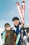 Smiling son and father with skis at