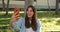 Smiling Spanish young woman making a video call in a park with a smart phone